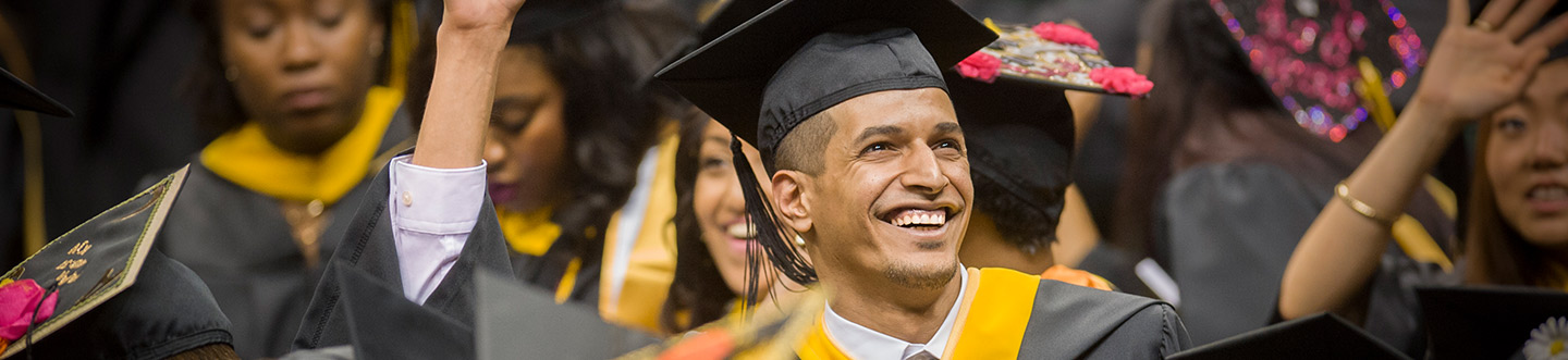 Graduate wearing mortar board smiling at Commencement